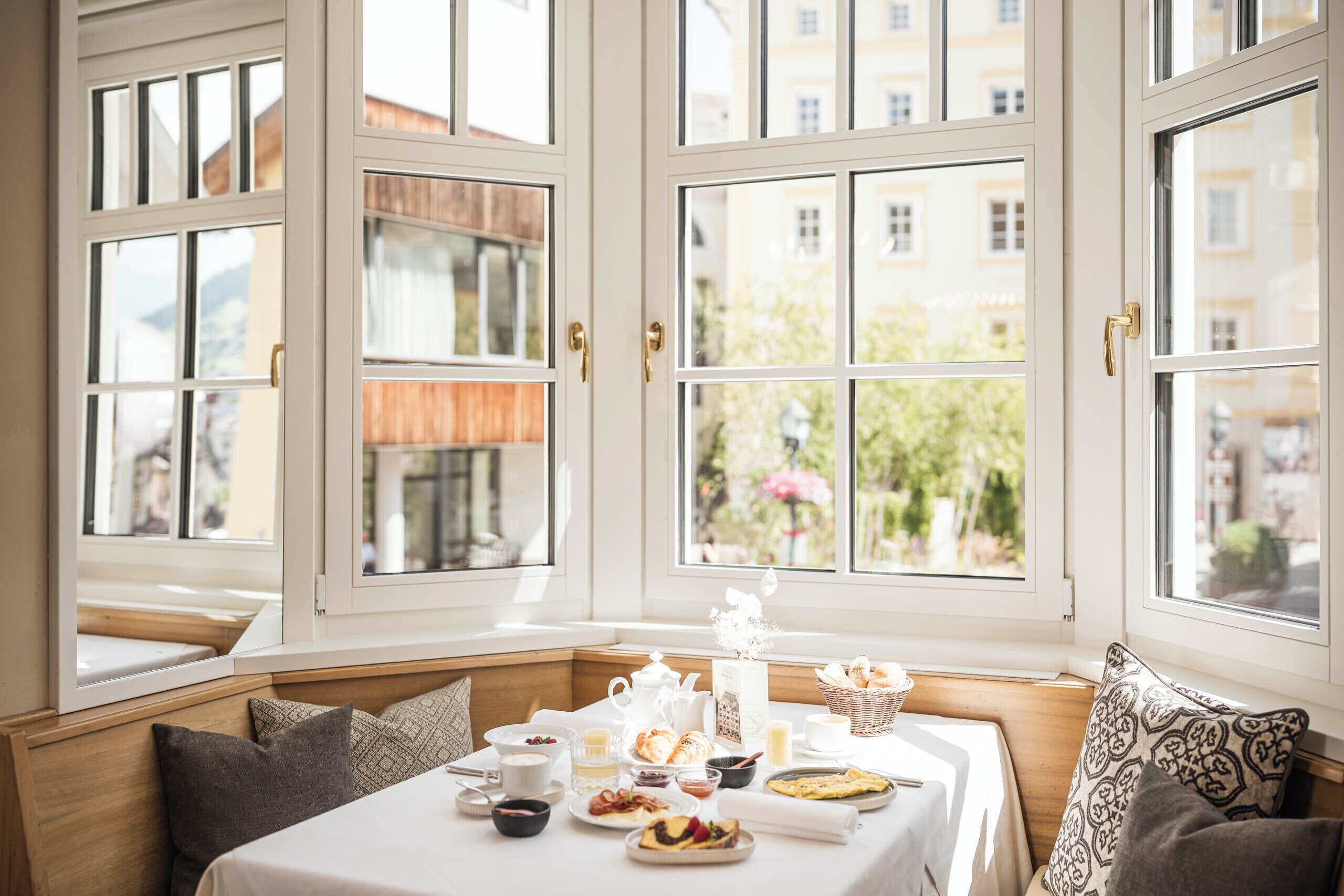 Una colazione servita con tavolo, posti a sedere e vista attraverso ampie finestre.