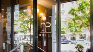 A hotel entrance with a glass door displaying the logo and name "HP Hotel Piacenza". - Hotel Piacenza (Milan)