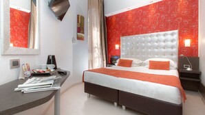 A modern hotel room with a large bed, a desk with a chair, and a mirror. - Hotel Piacenza (Milan)
