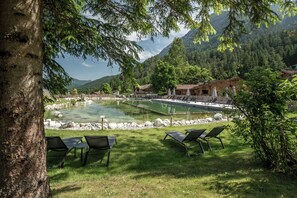 A serene lakeside setting with clear water, surrounded by lush greenery and mountains in the background. - VAYA Achensee (Achenkirch)