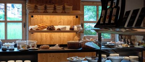 Ein Frühstücksbuffet mit Brot, Gebäck und Getränken.