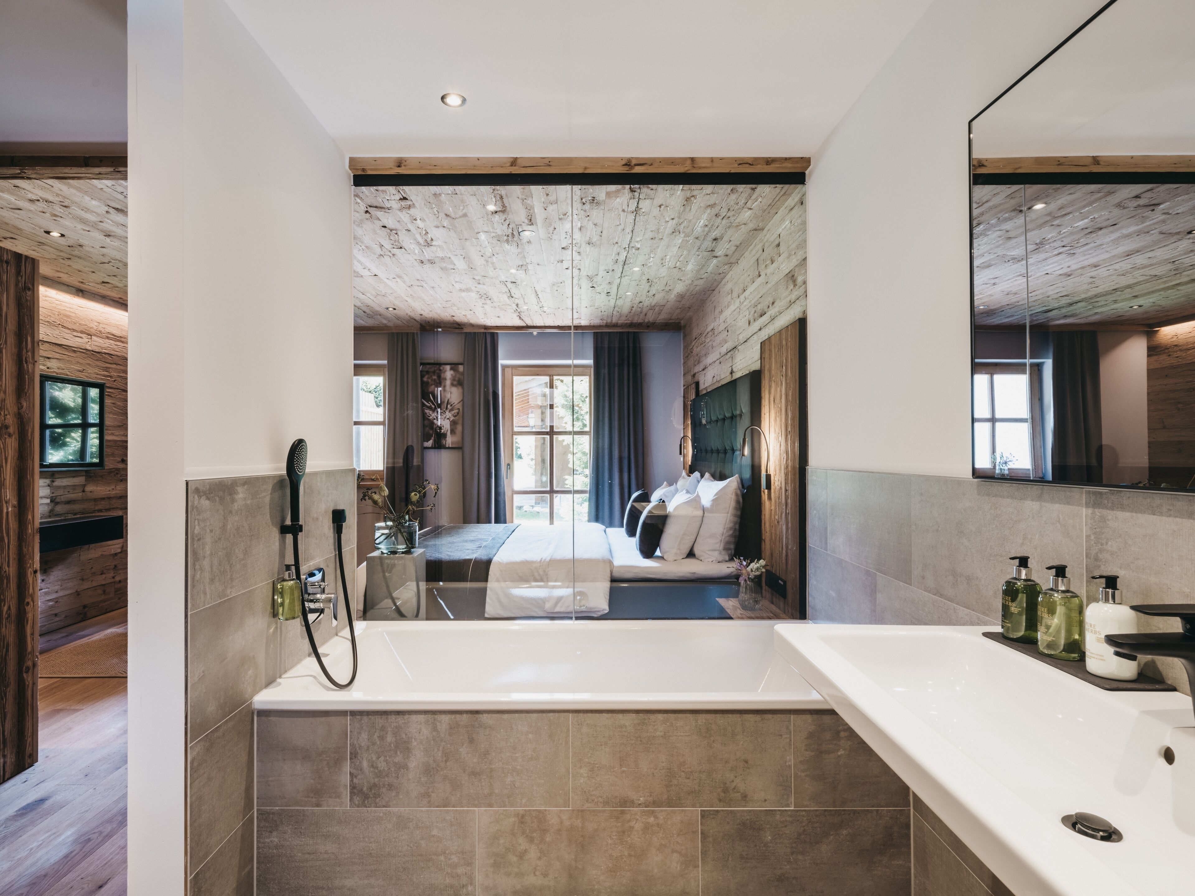 Un baño moderno con una bañera grande, una zona de ducha y un lavamanos con espejo.