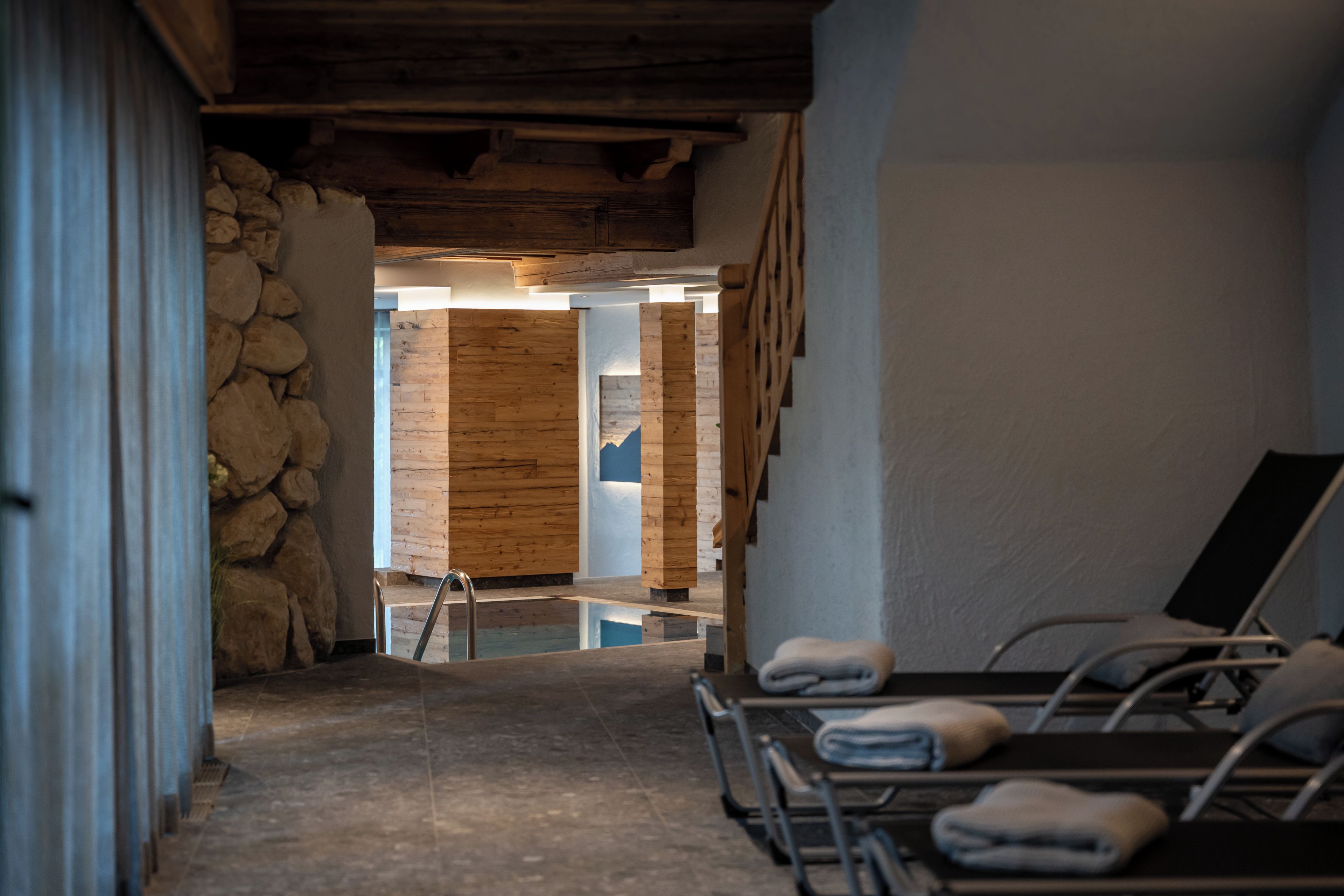A spa room with a stone wall, wooden paneling, and a reception area with a wooden door.