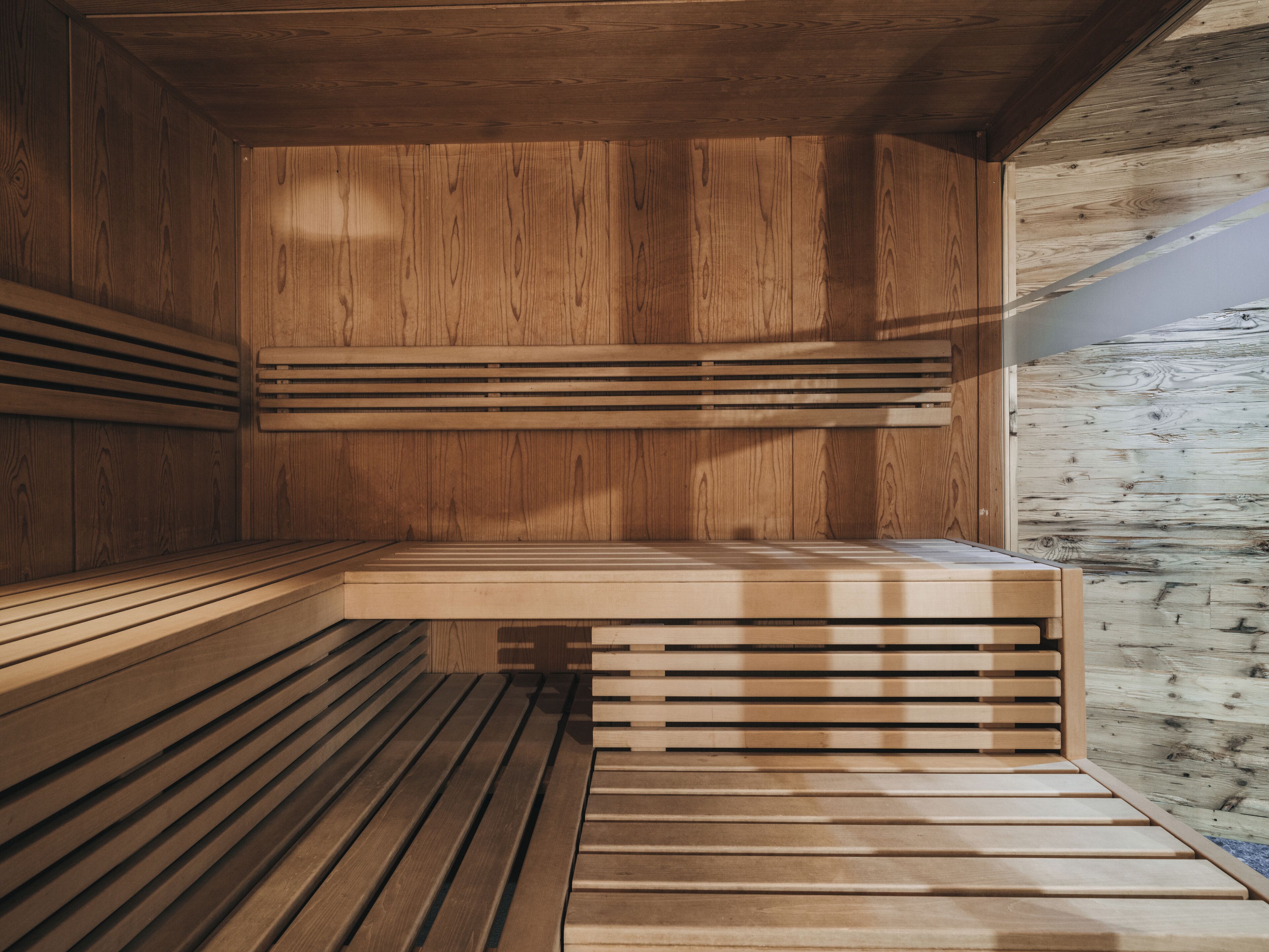 A wooden sauna with slatted benches and a wooden ceiling.