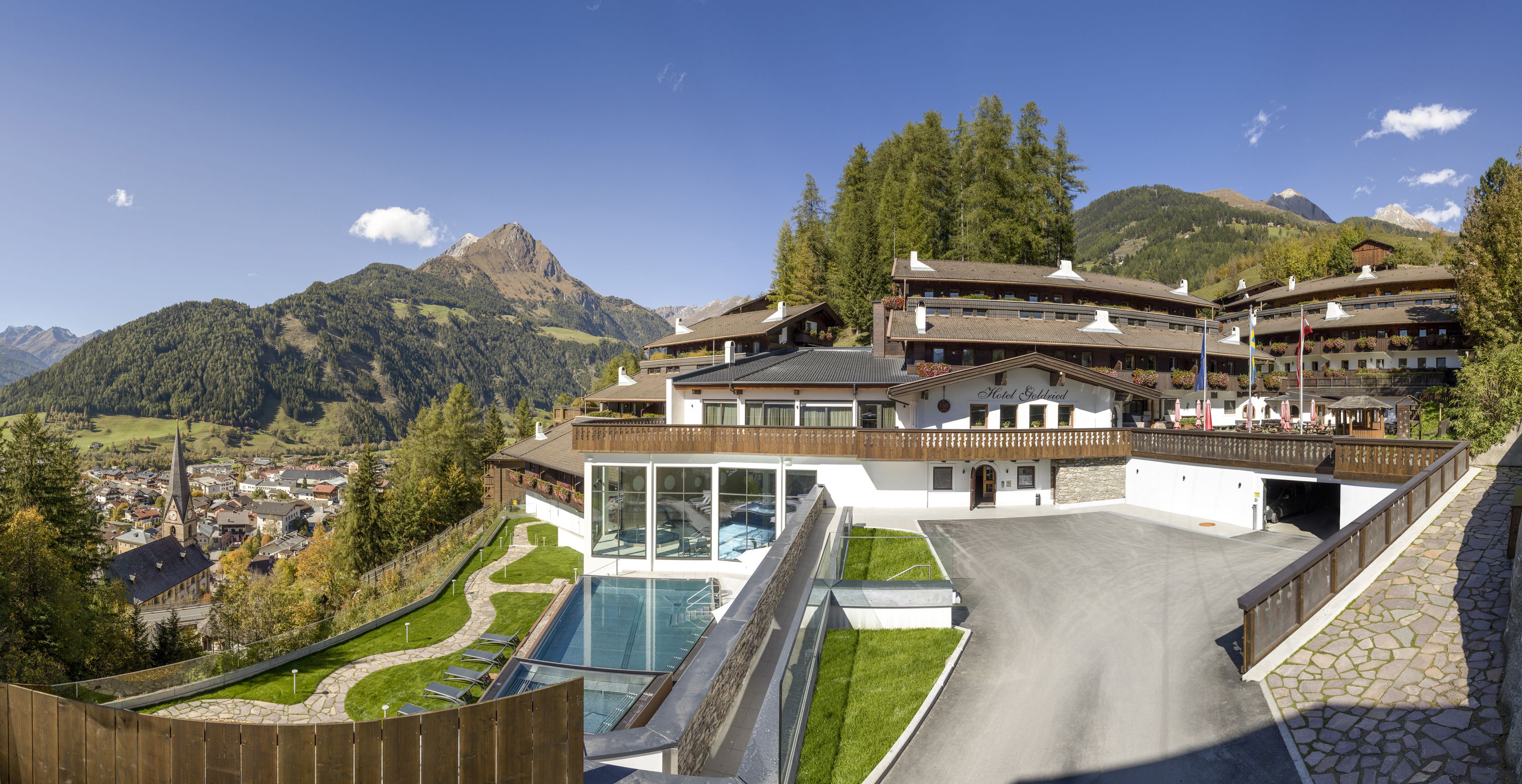 A hotel with a glass pool, a ski lift, and a mountain view.