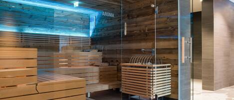 A modern spa area with wooden benches and a glass partition labeled "AROMA".