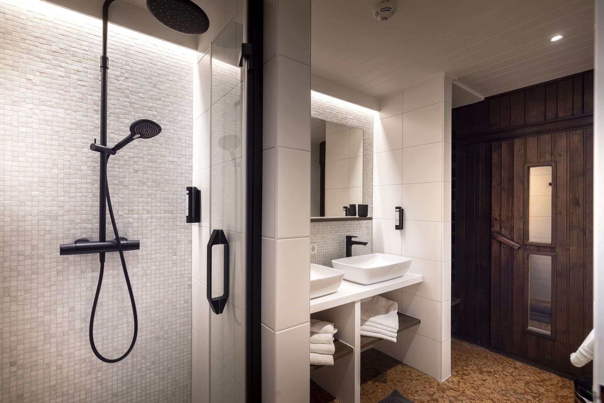 A modern bathroom with a shower, a sink, and a mirror.