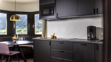 Una cocina moderna con microondas, cafetera y comedor con mesa y sillas.