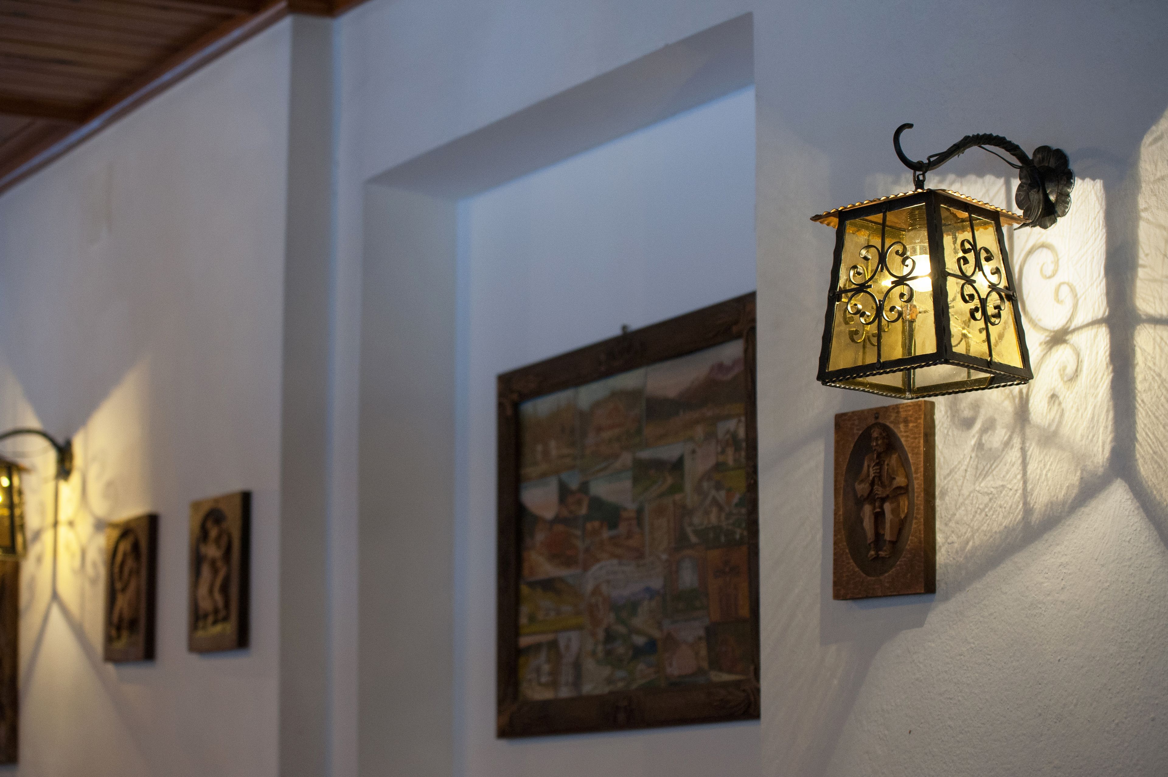 Una pared decorada con cuadros y una lámpara de pared.