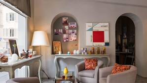 Un salon moderne comprenant un canapé, des fauteuils, une table basse et un mur agrémenté d’un élément décoratif.