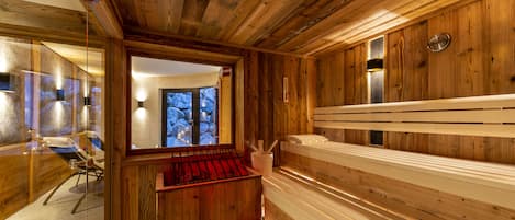 A wooden cabin interior with a sauna, a glass-walled shower area, and a wooden bench.