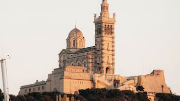 Un bâtiment historique doté d’une tour et d’un dôme imposants, entouré d’arbres et de bâtiments modernes.