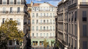 Un edificio de varios pisos con un patio central, con tiendas en la planta baja y balcones en los pisos superiores.