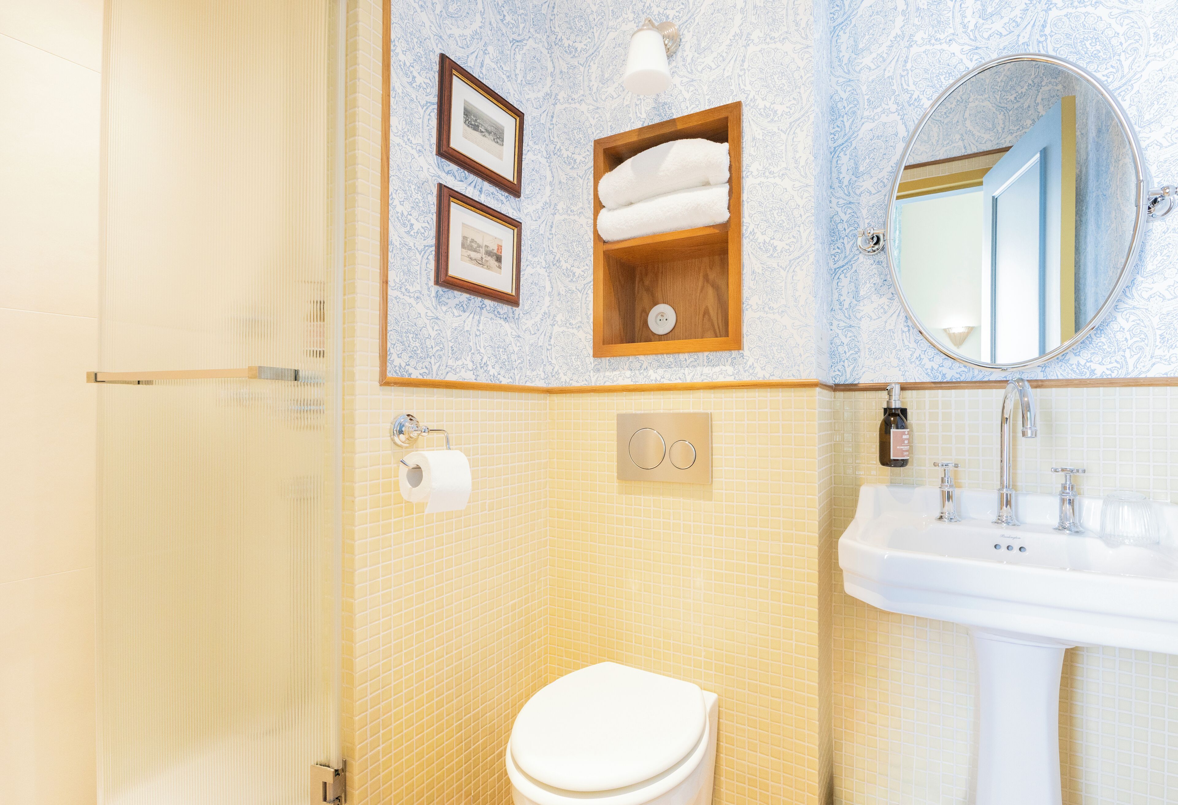 Ein Badezimmer mit Toilette, Waschbecken und gerahmten Bildern an der Wand.
