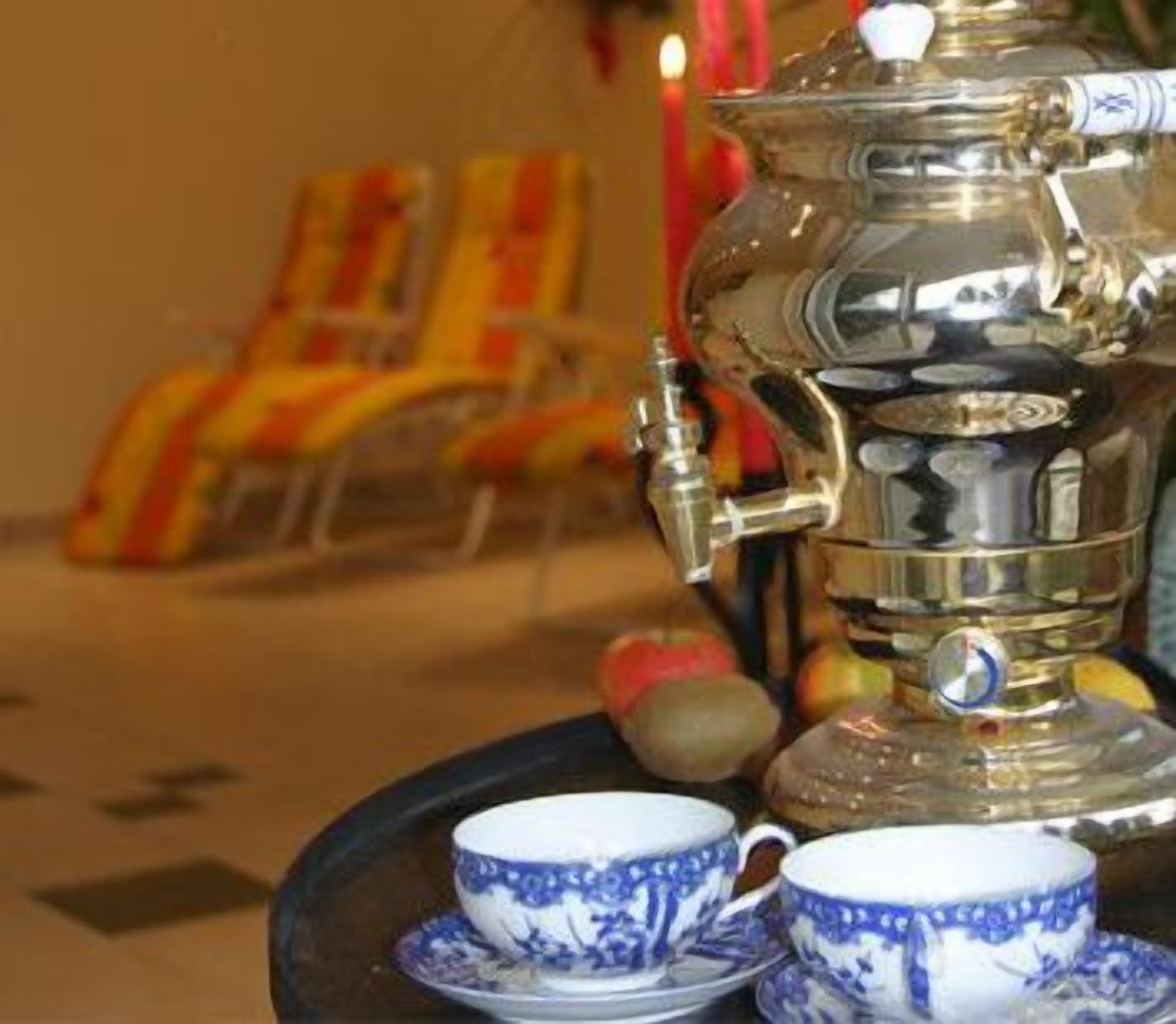 A traditional samovar with a teapot, a cup, and saucer on a tray.