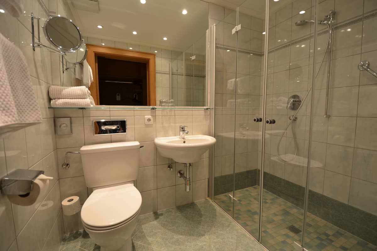 A modern bathroom with a toilet, sink, and glass-enclosed shower.