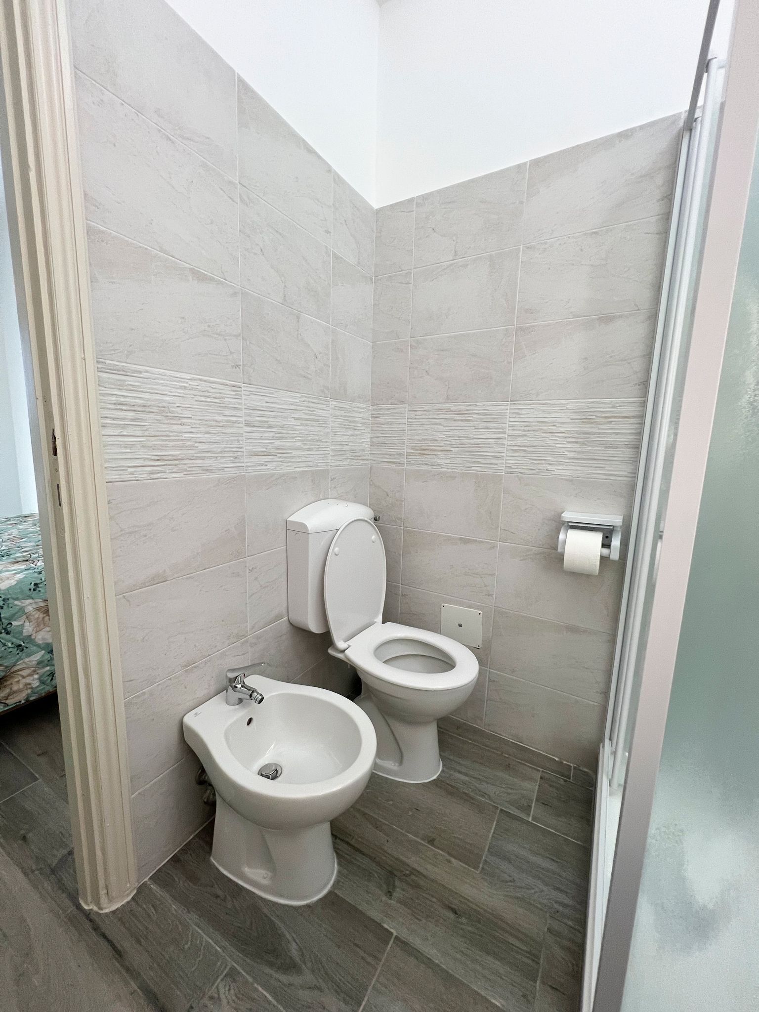 Une salle de bain moderne équipée d’un bidet, de toilettes et d’un espace douche.