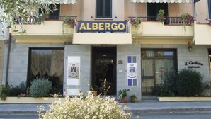 Un edificio con un letrero que dice "ALBERGO" y otro letrero para "il Cochio Ristorante".