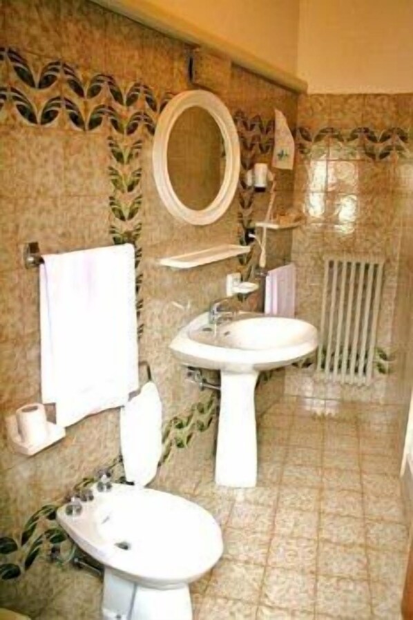 Un baño con inodoro, lavamanos y espejo.