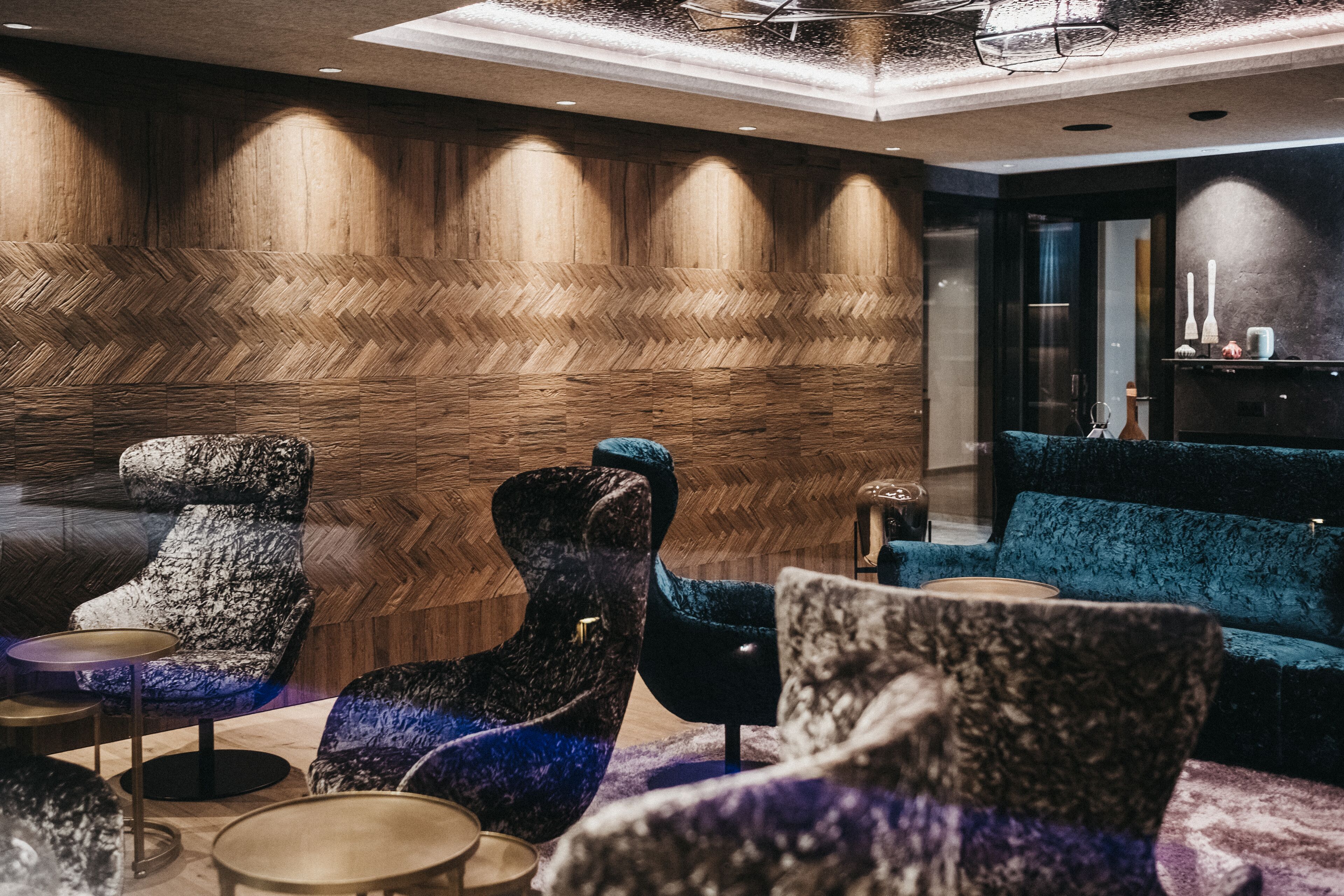 A modern lounge area with unique, textured chairs and a plush blue sofa.