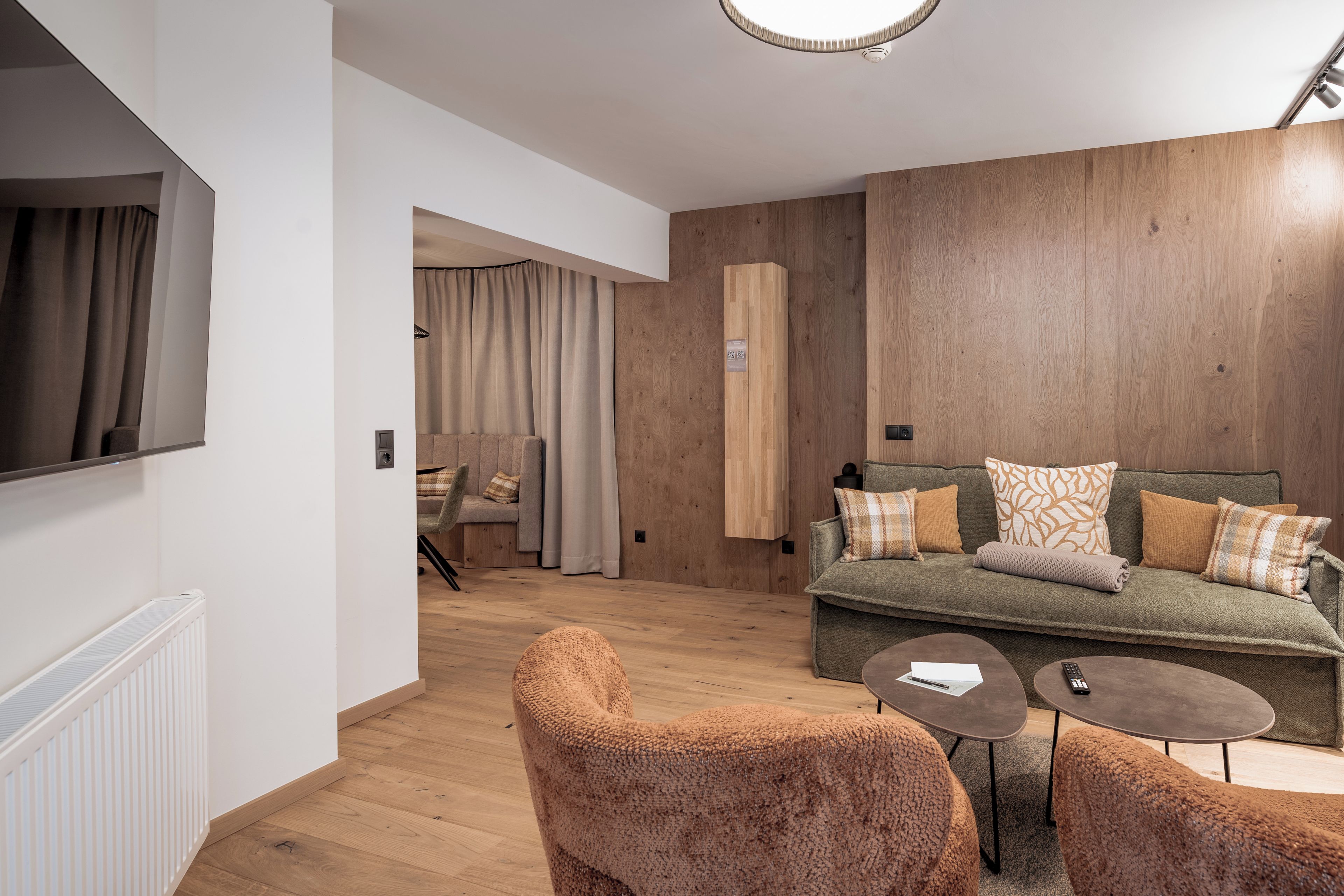 Una sala moderna con un sofá, dos sillones, una mesa de centro y un televisor.