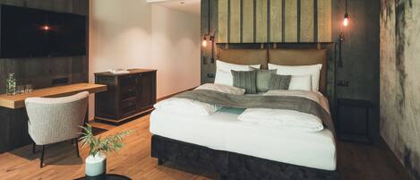 Un dormitorio moderno con una cama grande, un escritorio y un televisor.