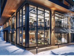 A modern building with large glass windows, a wooden interior, and a snow-covered ground. - Hotel Tirolerhof (Tux)
