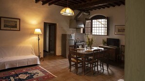Una cocina acogedora con una mesa de comedor, sillas, un sofá y un televisor.