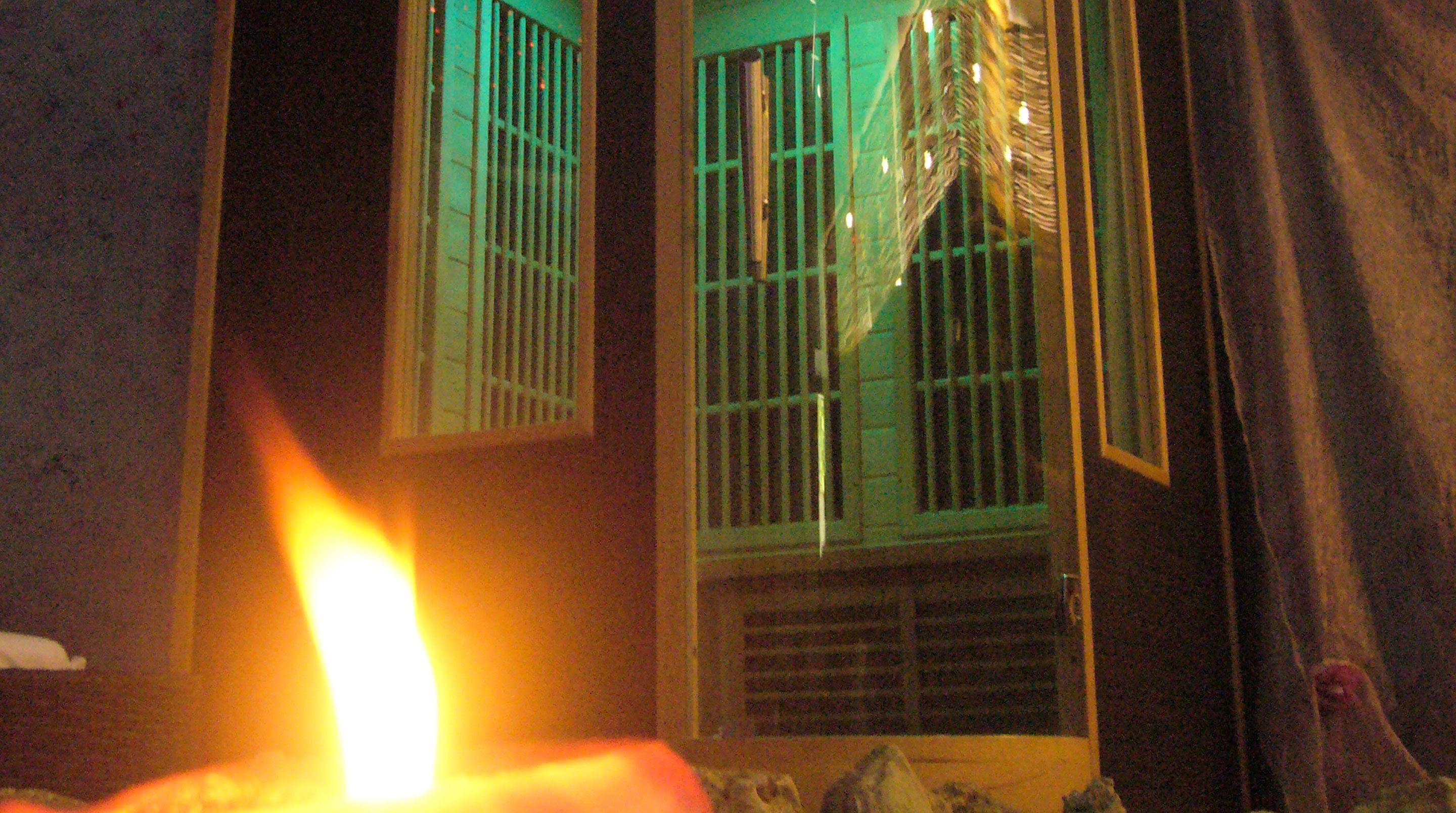 A room with a window featuring green bars and a visible curtain.