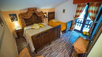 Un dormitorio con cama de madera, mesita de noche, silla y ventana con cortinas.