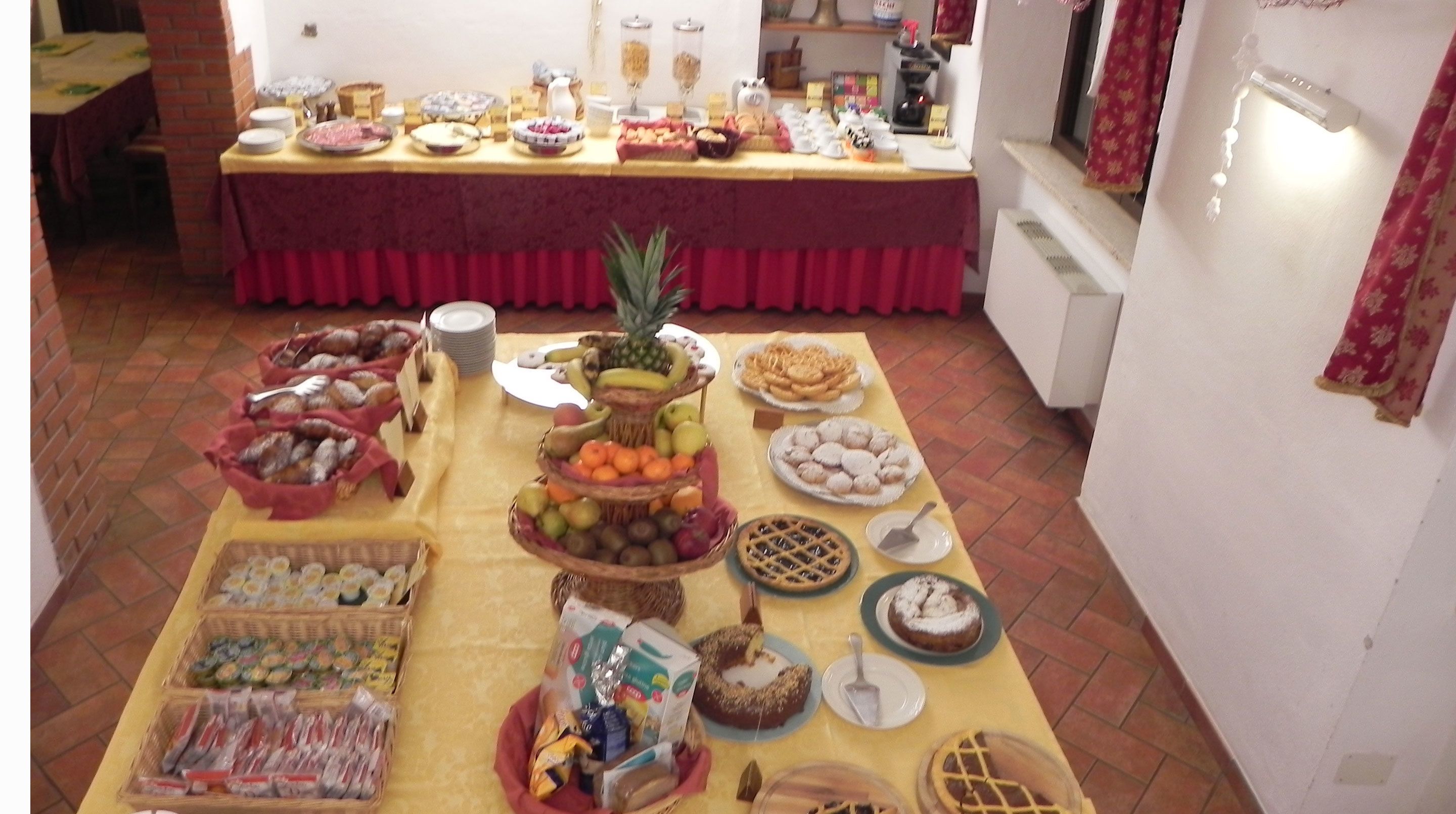 A buffet setup with various food items and a fruit display.