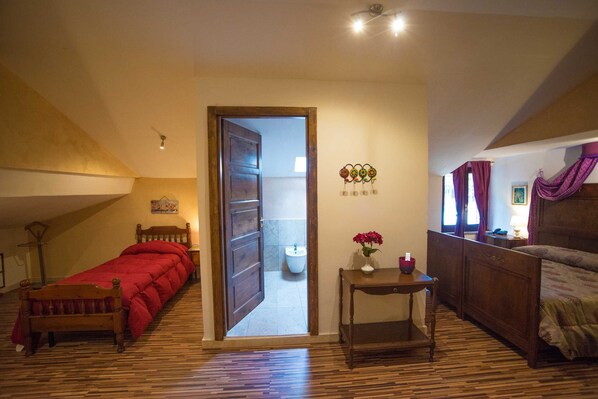 Un dormitorio con una cama de madera, una mesita de noche de madera y una pequeña mesa con un jarrón de flores.