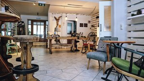 A spacious interior with a wooden table, chairs, and a staircase leading to an upper level. - Hotel Tannenhof (Waengle)