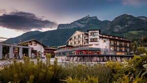 A hotel with a mountain backdrop, featuring a modern design with multiple floors and large windows. - Hotel Klingler (Eben am Achensee)