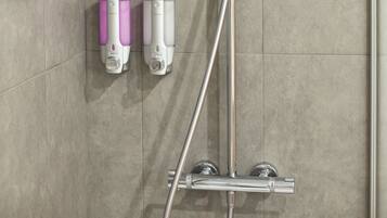 A modern shower with a handheld showerhead, a wall-mounted faucet, and two soap dispensers.