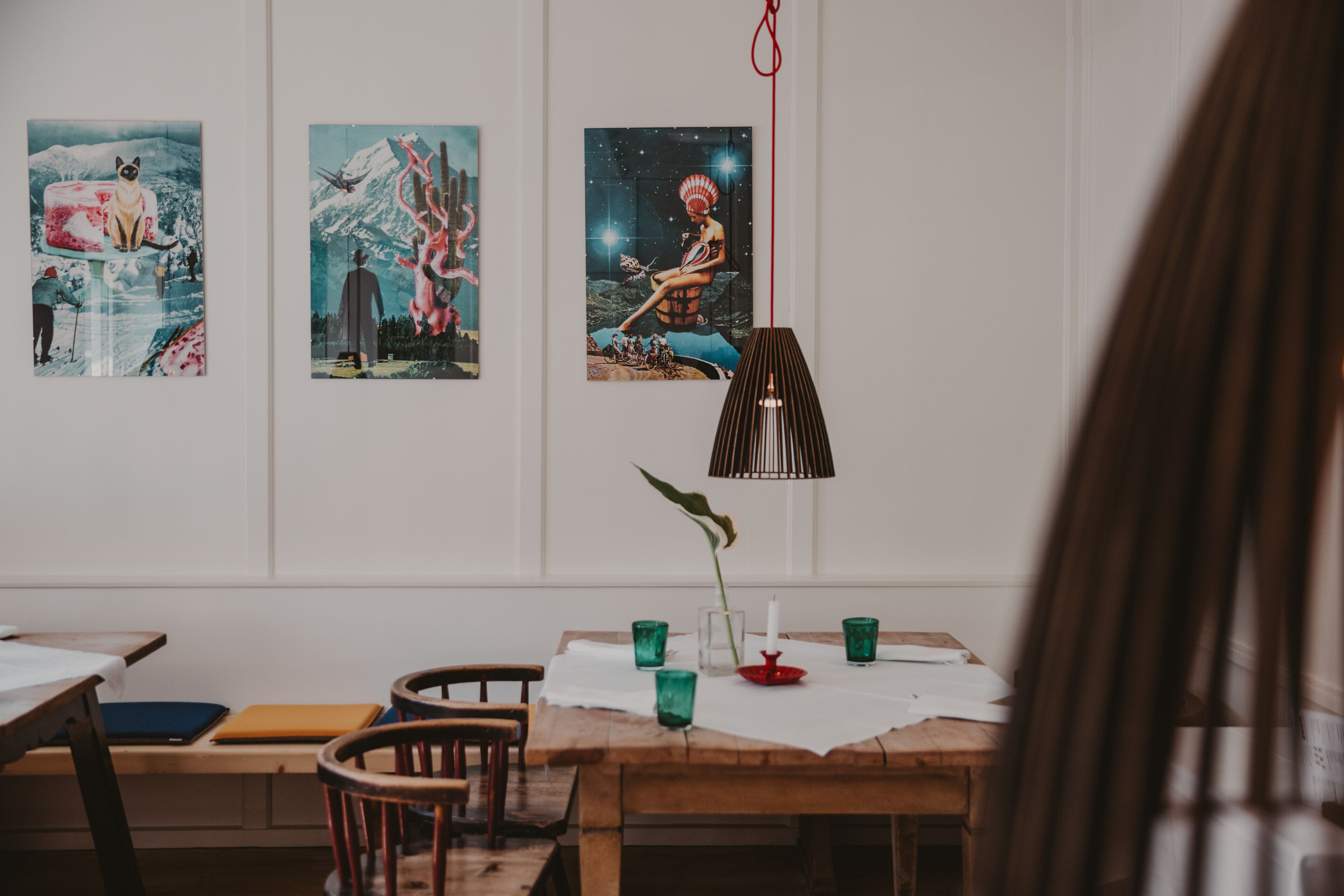 A dining area with a wooden table, chairs, and a hanging lamp.