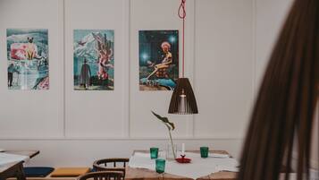 A dining area with a wooden table, chairs, and a hanging lamp.
