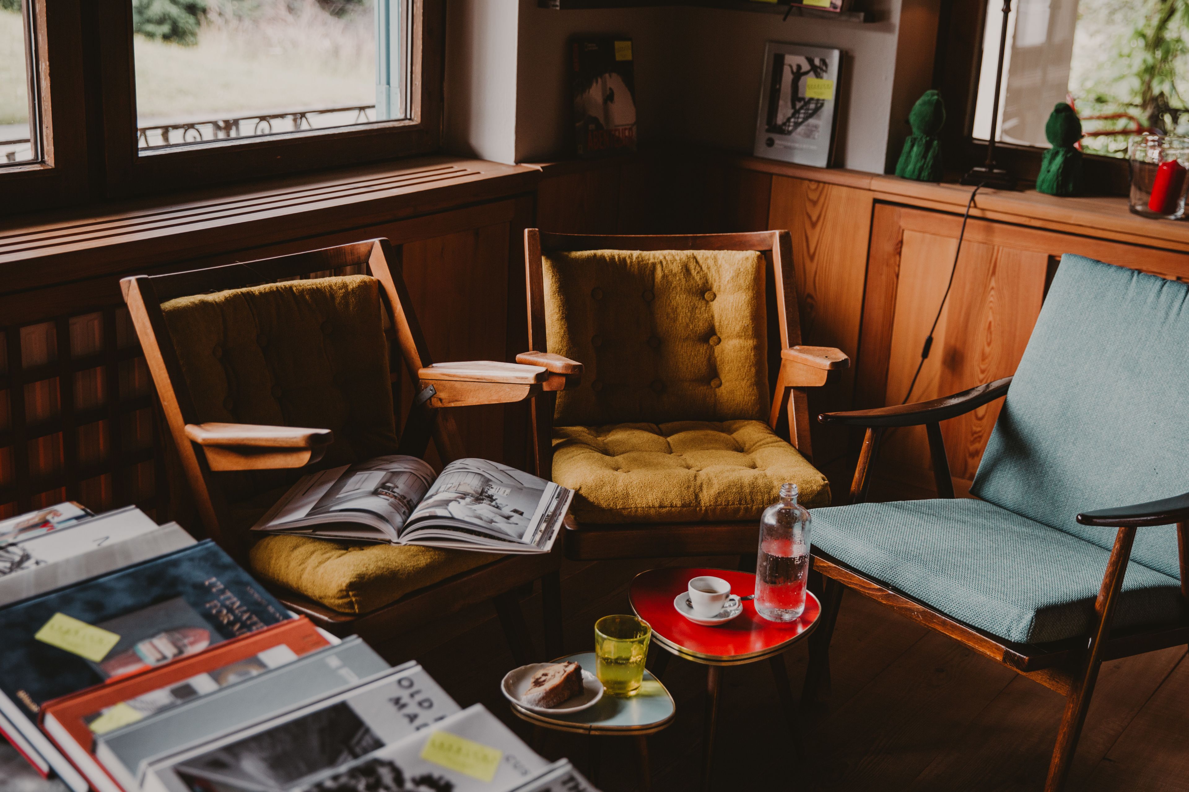 A cozy reading nook with two chairs, a small table with a book, a cup, and a glass of water.