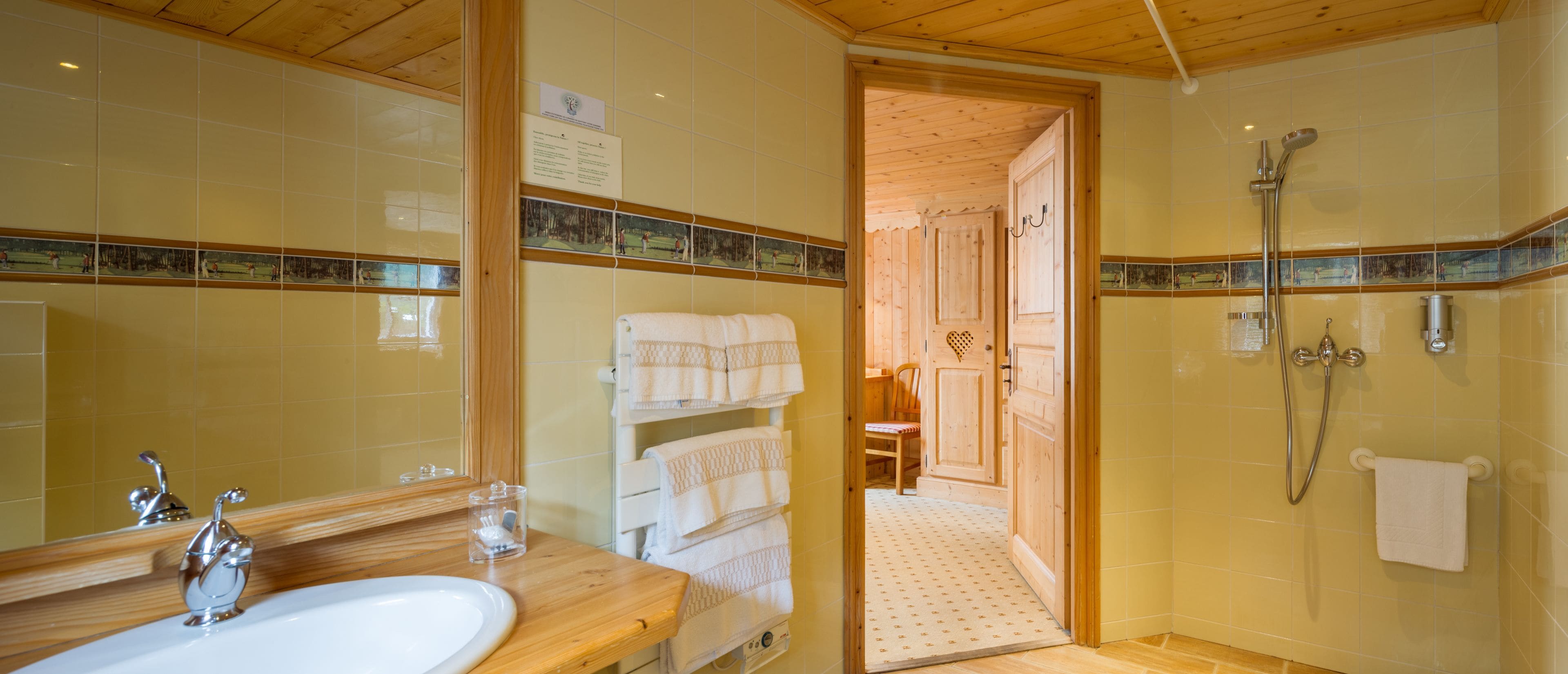 Un baño con tocador de madera, un lavabo, un espejo y zona de ducha.