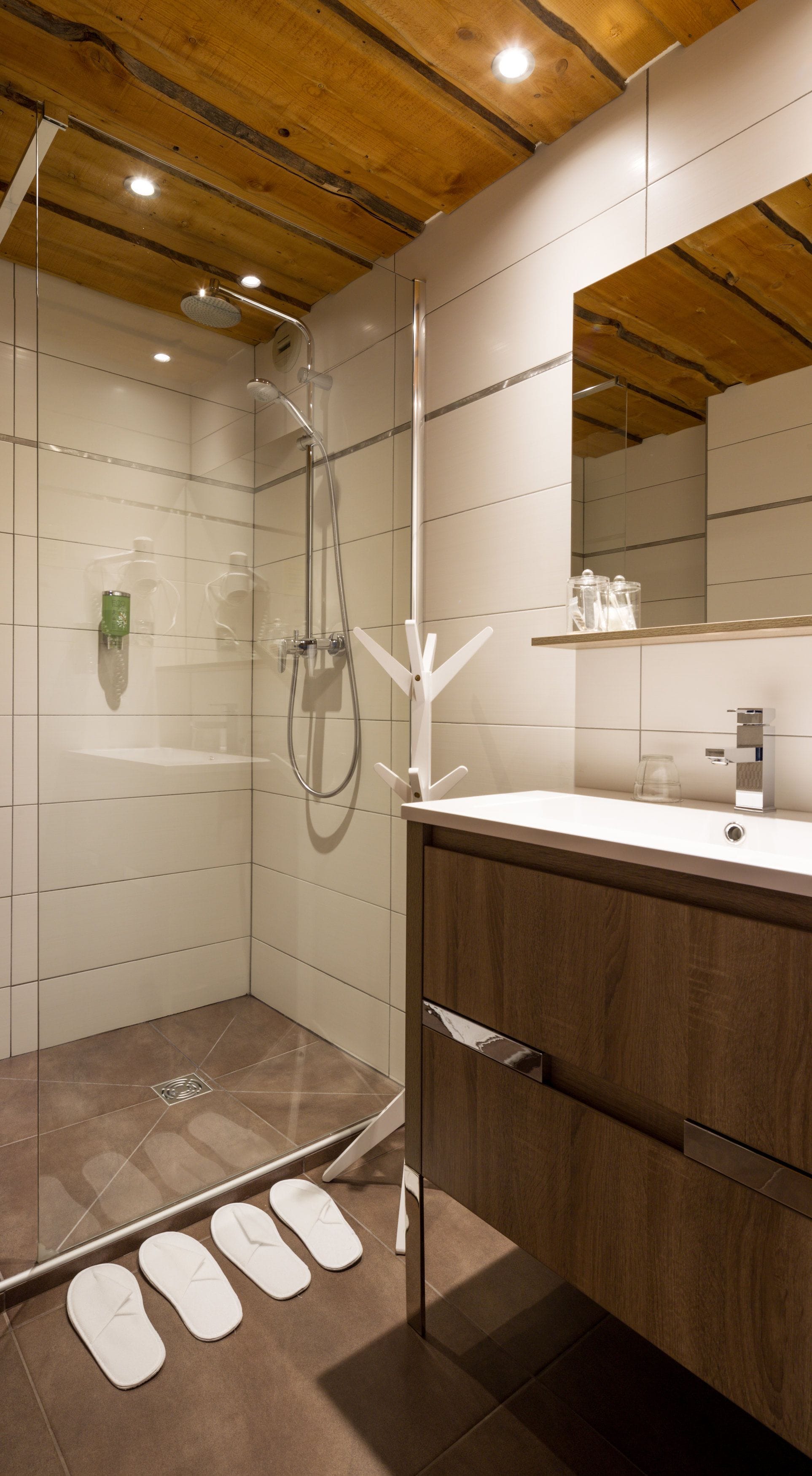 Un baño moderno con ducha, tocador y espejo.