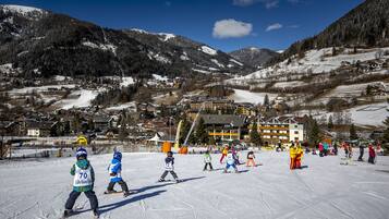 A ski resort with a ski slope, buildings, and mountains in the background.