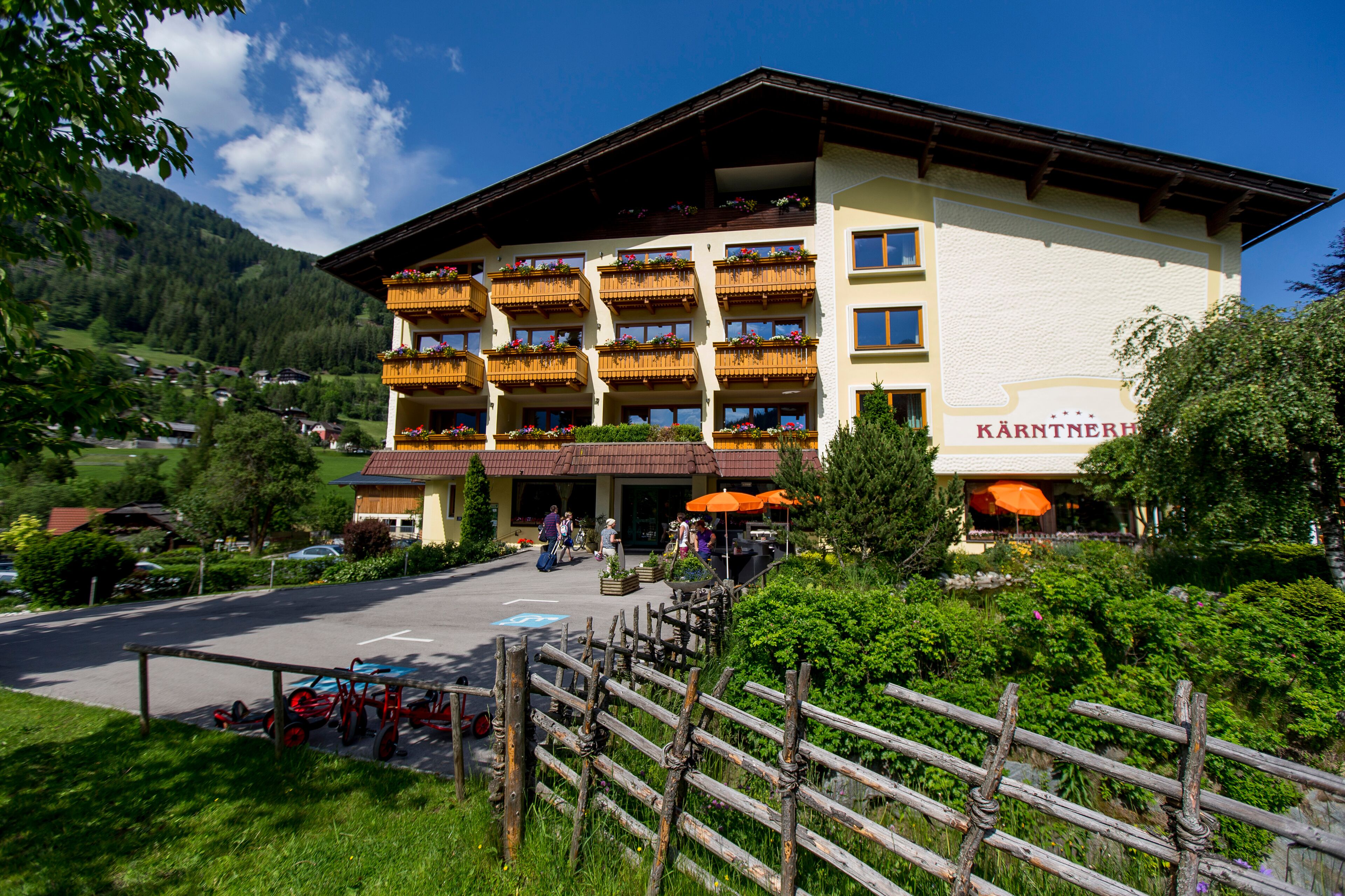Hotel com várias varandas, área de estar ao ar livre e vista para o verde ao redor.
