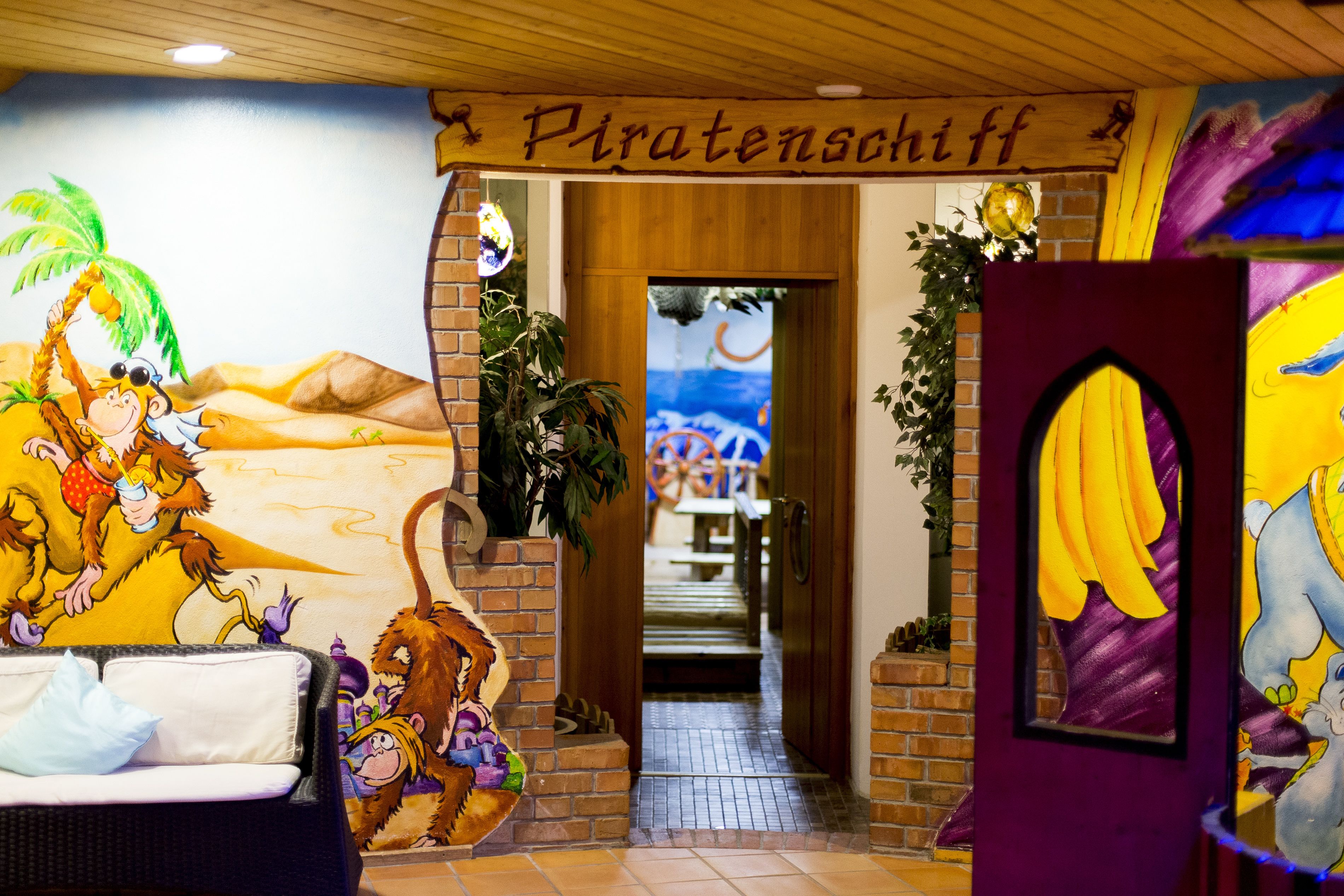 Una hall con un murale raffigurante una scimmia e un leone, un cartello con su scritto 