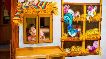 Una veduta attraverso una finestra, un gallo e una gallina raffigurati sulla parete.