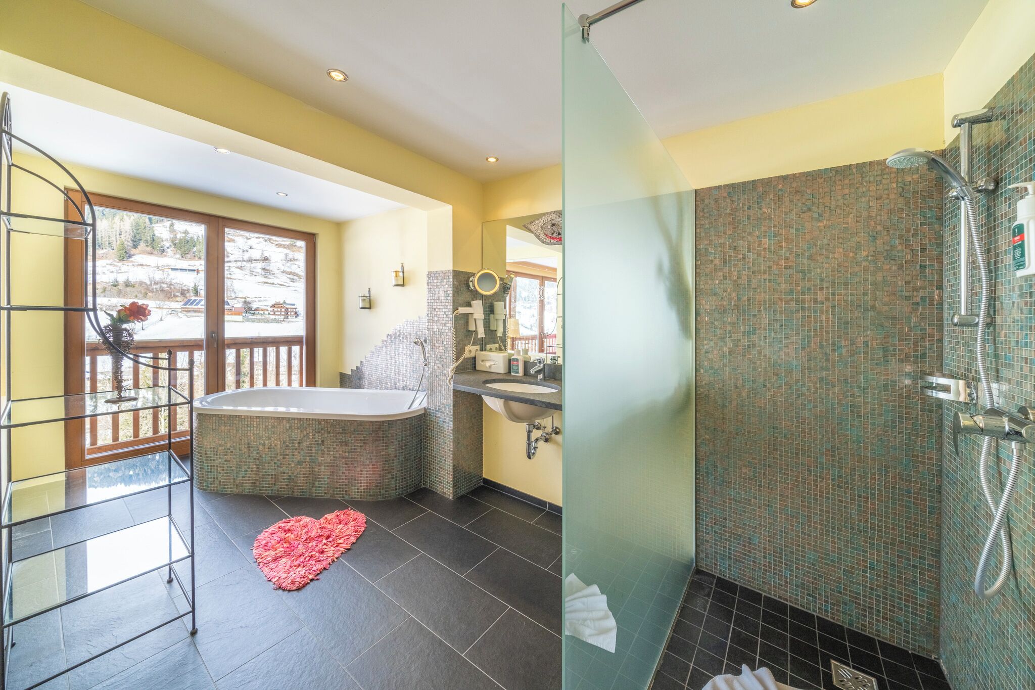 Une salle de bain équipée d’une baignoire, d’une douche et d’un espace de douche séparé par des parois en verre.