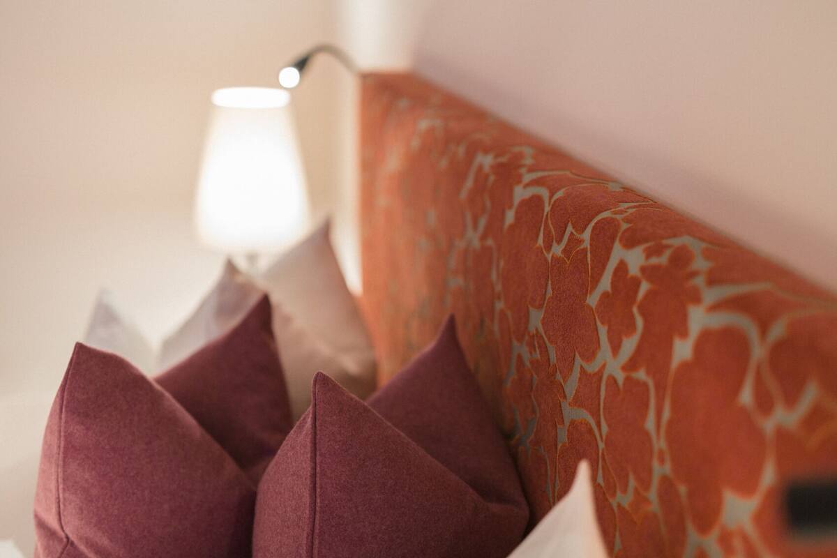 A close-up of a sofa with a patterned cushion and several pillows.