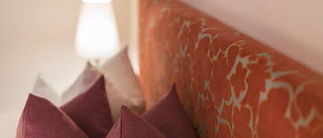 A close-up of a sofa with a patterned cushion and several pillows.