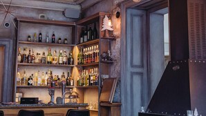 A bar area with shelves of bottles, a fireplace, and hanging light bulbs. - Hotel Eden Chamonix (Chamonix-Mont-Blanc)