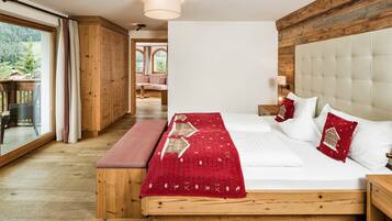Un dormitorio con una cama grande, piso de madera y vista a una terraza y zona exterior.