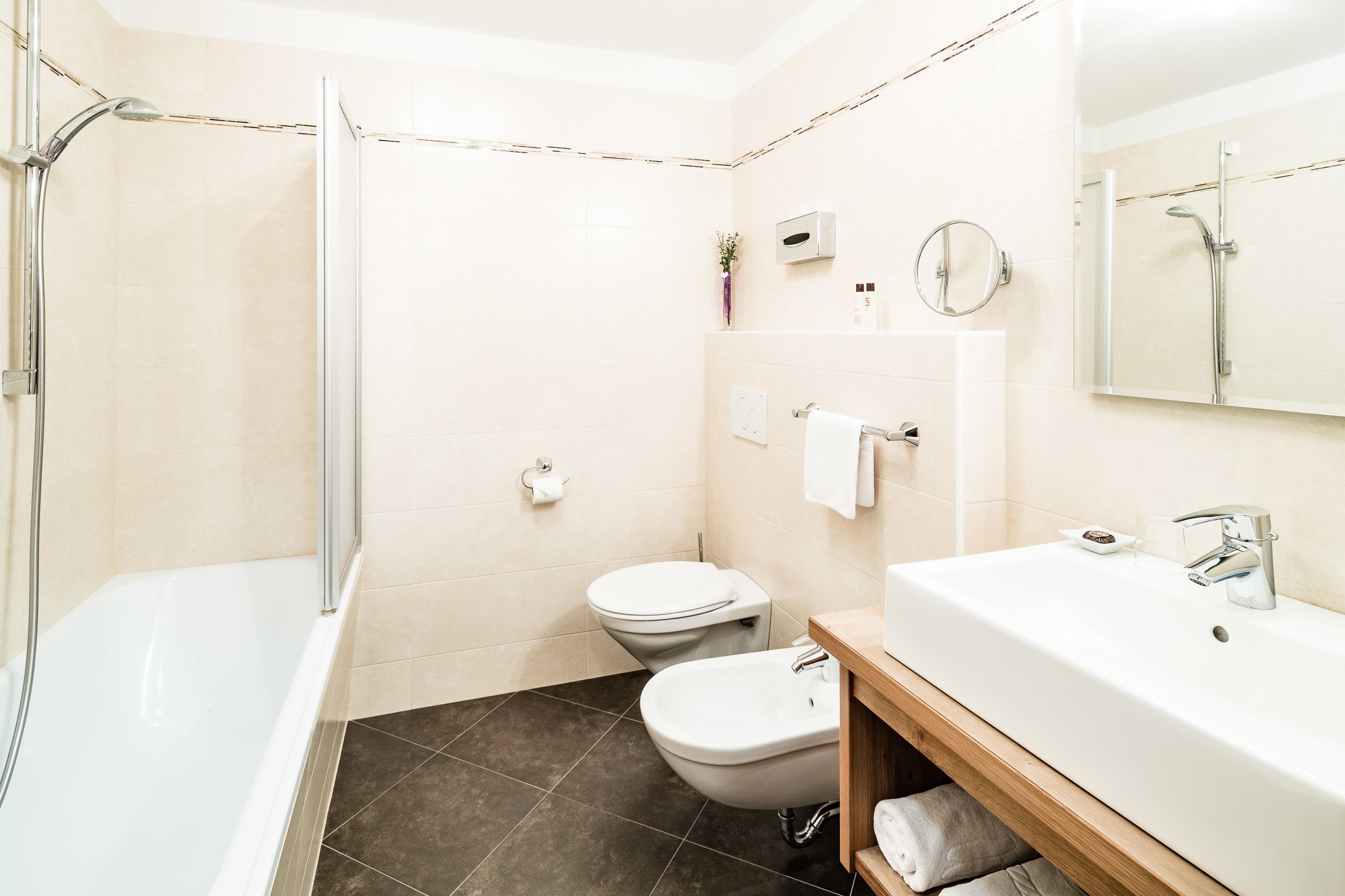 A modern bathroom with a bathtub, toilet, and sink.
